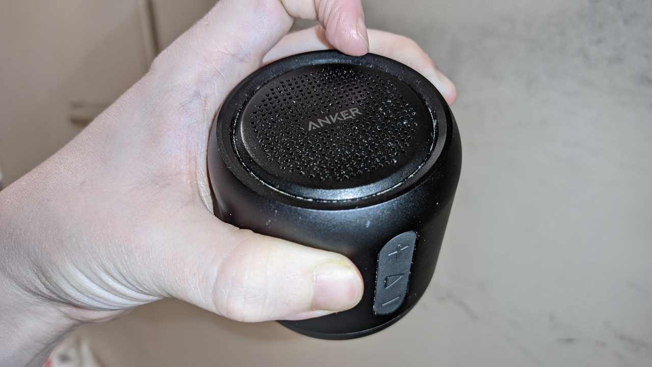 Soundcore Mini Speaker, gripped in my hand.